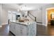 Open kitchen with marble island, gray cabinets, and view to the living spaces at 482 Pearl Cove Ct, Atlanta, GA 30350