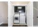 Convenient laundry closet with washer, dryer, and upper cabinets for storage at 482 Pearl Cove Ct, Atlanta, GA 30350
