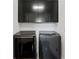 Modern laundry room featuring front loading washer and dryer with cabinets for storage at 482 Pearl Cove Ct, Atlanta, GA 30350