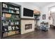 Inviting living room with stone fireplace, dark wood floors, built-in shelving and a bar cart at 482 Pearl Cove Ct, Atlanta, GA 30350