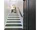 Elegant stairway featuring dark wood steps, white risers, and a modern black accent door at 482 Pearl Cove Ct, Atlanta, GA 30350