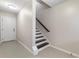 Bright stairwell featuring tiled floors, white trim, and dark wood handrail at 482 Pearl Cove Ct, Atlanta, GA 30350