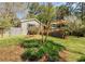 Landscaped backyard showcasing a charming brick home, wooden deck, and lush greenery at 1488 Drayton Woods Dr, Tucker, GA 30084