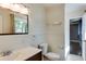 Bathroom featuring a wood vanity, white walls with molding, toilet, and view to next room at 1488 Drayton Woods Dr, Tucker, GA 30084