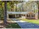 Charming single-story home with brick and siding exterior, lush lawn, and an attached garage in a wooded setting at 1488 Drayton Woods Dr, Tucker, GA 30084