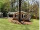 Well-maintained brick home with an attached garage, lush lawn, and mature trees offering shade and privacy at 1488 Drayton Woods Dr, Tucker, GA 30084