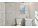 Clean bathroom featuring white tile, toilet, and a vanity with a gray cabinet at 1591 Athens Sw Ave, Atlanta, GA 30310
