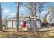 Charming home exterior with a red front door, gray siding, and mature trees, nestled on a lot at 1591 Athens Sw Ave, Atlanta, GA 30310
