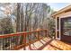 Back deck of home featuring wood floors, dark railings and views of the woods at 2405 Millwater Xing, Dacula, GA 30019