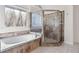 Bathroom featuring shower with glass door and a soaking tub with custom tile at 2405 Millwater Xing, Dacula, GA 30019