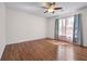Bright bedroom featuring hardwood floors, a ceiling fan, and natural light from a window with blue patterned curtains at 2405 Millwater Xing, Dacula, GA 30019