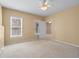 Spacious bedroom featuring neutral carpet, ceiling fan, and large window at 2405 Millwater Xing, Dacula, GA 30019