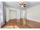 This bedroom features hardwood floors, a ceiling fan, an open closet, and entry to another room at 2405 Millwater Xing, Dacula, GA 30019