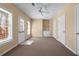 Large bonus room with neutral carpet, built-in shelving and cabinets, and multiple windows at 2405 Millwater Xing, Dacula, GA 30019