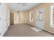 Large bonus room featuring multiple windows, neutral carpet, ceiling fan, and access to the backyard at 2405 Millwater Xing, Dacula, GA 30019