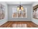 Bright dining room with hardwood floors, large windows, and stylish chandelier at 2405 Millwater Xing, Dacula, GA 30019