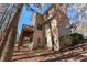 Angle view of two-story home featuring a deck, stairs, and wooded scenery at 2405 Millwater Xing, Dacula, GA 30019