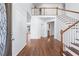 Bright foyer with hardwood floors, white walls, a staircase, and a view into other rooms at 2405 Millwater Xing, Dacula, GA 30019