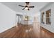 Open-concept living room featuring hardwood floors, ceiling fan, and view to the kitchen area at 2405 Millwater Xing, Dacula, GA 30019