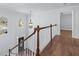 Upstairs hallway with wood floors, natural light, decorative lighting, and views of the foyer at 2405 Millwater Xing, Dacula, GA 30019