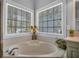 Close-up of a bathtub with corner windows offering natural light, enhancing the relaxing atmosphere at 4162 Crowder Nw Dr, Kennesaw, GA 30152