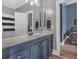 Bathroom featuring a blue vanity, mirror, and shower with a navy striped curtain, offering a stylish and functional space at 4162 Crowder Nw Dr, Kennesaw, GA 30152
