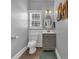 Powder room with gray vanity, wood-look floors, and stylish lighting at 4162 Crowder Nw Dr, Kennesaw, GA 30152