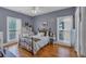 Bright bedroom featuring hardwood floors, ample natural light from dual windows, and a comfortable bed with neutral bedding at 4162 Crowder Nw Dr, Kennesaw, GA 30152