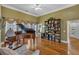 Open-concept living room features hardwood floors, a piano, and built-in bookshelves at 4162 Crowder Nw Dr, Kennesaw, GA 30152