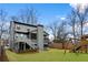 Large backyard with playset, screened porch, deck, lush lawn, and mature trees at 1299 Sunland Ne Dr, Brookhaven, GA 30319