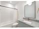 Bright bathroom featuring modern vanity with stone countertop, framed mirror, tub, and tiled shower at 1299 Sunland Ne Dr, Brookhaven, GA 30319
