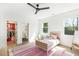 Bright bedroom features hardwood floors, a colorful rug, and two windows at 1299 Sunland Ne Dr, Brookhaven, GA 30319