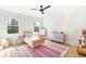Bright bedroom features hardwood floors, a colorful rug, and two windows at 1299 Sunland Ne Dr, Brookhaven, GA 30319