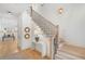 Bright foyer with wooden floors, staircase with black railings, console table and decorative round wall mirrors at 1299 Sunland Ne Dr, Brookhaven, GA 30319