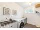 Well-lit laundry room with modern washer and dryer, sink, and neutral-toned cabinetry for a clean aesthetic at 1299 Sunland Ne Dr, Brookhaven, GA 30319