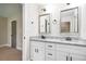 Elegant bathroom featuring double sinks with granite counters, white cabinets, and decorative framed mirrors at 1972 Cambridge Ave, Atlanta, GA 30337