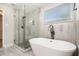 The primary bathroom features a glass shower, soaking tub, and tiled accent wall at 1972 Cambridge Ave, Atlanta, GA 30337