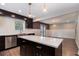 Modern kitchen with stainless steel appliances, island, dark cabinets, and view to living room at 1972 Cambridge Ave, Atlanta, GA 30337