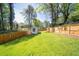 Expansive backyard featuring a lush lawn, wooden fence, and charming storage shed at 308 Reed St, Scottdale, GA 30079