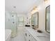 Bright bathroom featuring double sinks, marble countertops, glass enclosed shower, and soaking tub at 308 Reed St, Scottdale, GA 30079