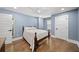 Serene bedroom with hardwood floors, soft blue walls, and plenty of natural light at 308 Reed St, Scottdale, GA 30079