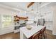 Bright open kitchen with white cabinets, stainless steel appliances, island seating, and pendant lighting at 308 Reed St, Scottdale, GA 30079
