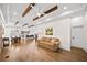 Open-concept living room with wood floors, exposed beams, recessed lighting, and seamlessly connected to the kitchen at 308 Reed St, Scottdale, GA 30079