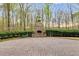 Outdoor stone fireplace in large backyard with paved patio surrounded by greenery at 4231 Carrington Ct, Douglasville, GA 30135