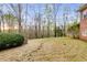 Large grassy backyard with a stone wall and view of the wooded area behind the house at 4231 Carrington Ct, Douglasville, GA 30135
