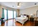 Bright bedroom with hardwood floors, large windows with blinds and curtains, with ceiling fan and lamps at 4231 Carrington Ct, Douglasville, GA 30135