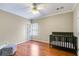 Bright room with hardwood floors features ceiling fan and a dark wood crib for a young  at 4231 Carrington Ct, Douglasville, GA 30135