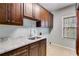 Laundry room with white granite countertops, dark wood cabinets, and window with natural light at 4231 Carrington Ct, Douglasville, GA 30135