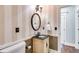 Charming powder room featuring decorative wallpaper, oval mirror, and unique vanity at 4231 Carrington Ct, Douglasville, GA 30135
