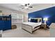 Serene bedroom with a striking blue accent wall, complemented by stylish furniture and a bright, airy atmosphere at 6407 Barker Station Walk, Sugar Hill, GA 30518